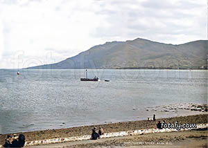 An old Warrenpoint image that has been restored, HD enhanced and colourised of a boat on a calm Carlingford Lough with the beautiful Cooley Mountains in the background.