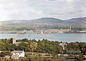 Old image of Warrenpoint harbour with the Mourne mountains in the background. The image has been fully restored, HD enhanced and colourised