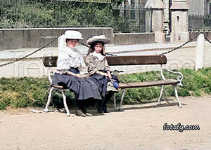 An old image that has been restored and colourised of two girls enjoying the sunshine at Warrenpoint seafront.