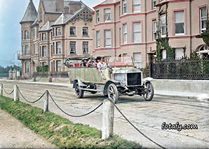 An old image that has been colourised and restored of an early passenger bus on Warrenpoint seafront