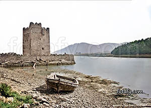 An old image of a dry docked rowing boat and the 16th century Narrow Water castle, Warrenpoint. The image had been restored HD enhanced and colourised.