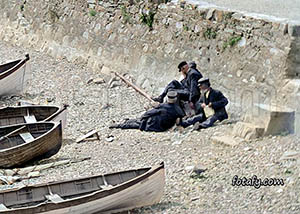 An old image that has been fully restored and colourised of boatmen taking a break at Warrenpoint sea front.