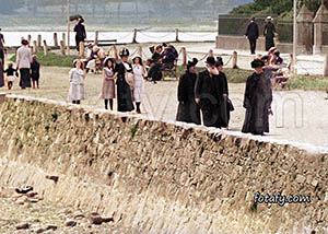 An old image of people strolling along the promenade in Warrenpoint. The image has been restored, colourised and HD enhanced.